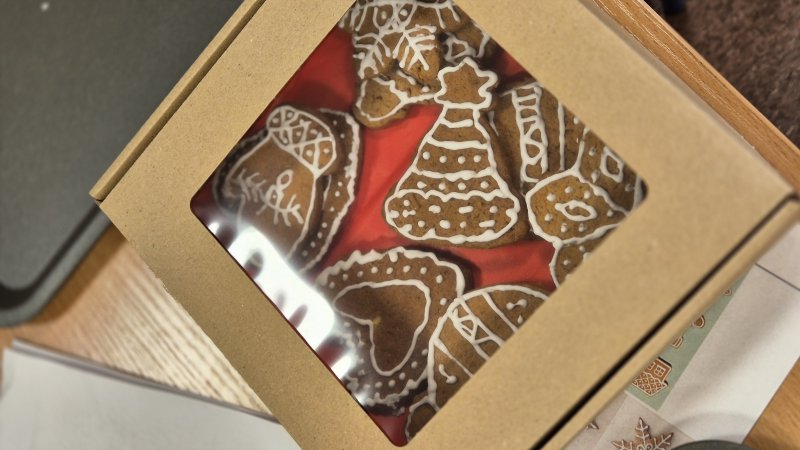 Zestaw świątecznych pierniczków zdobionych białym lukrem w kartonowym pudełku