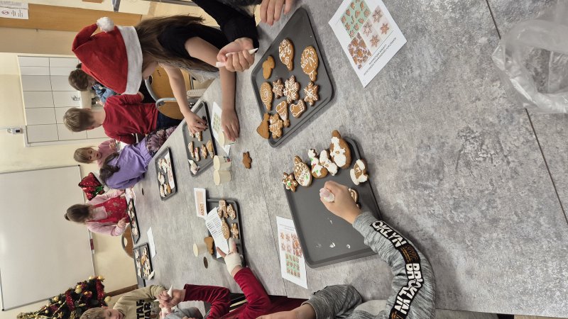 Dzieci dekorujące pierniki lukrem podczas warsztatów w pracowni